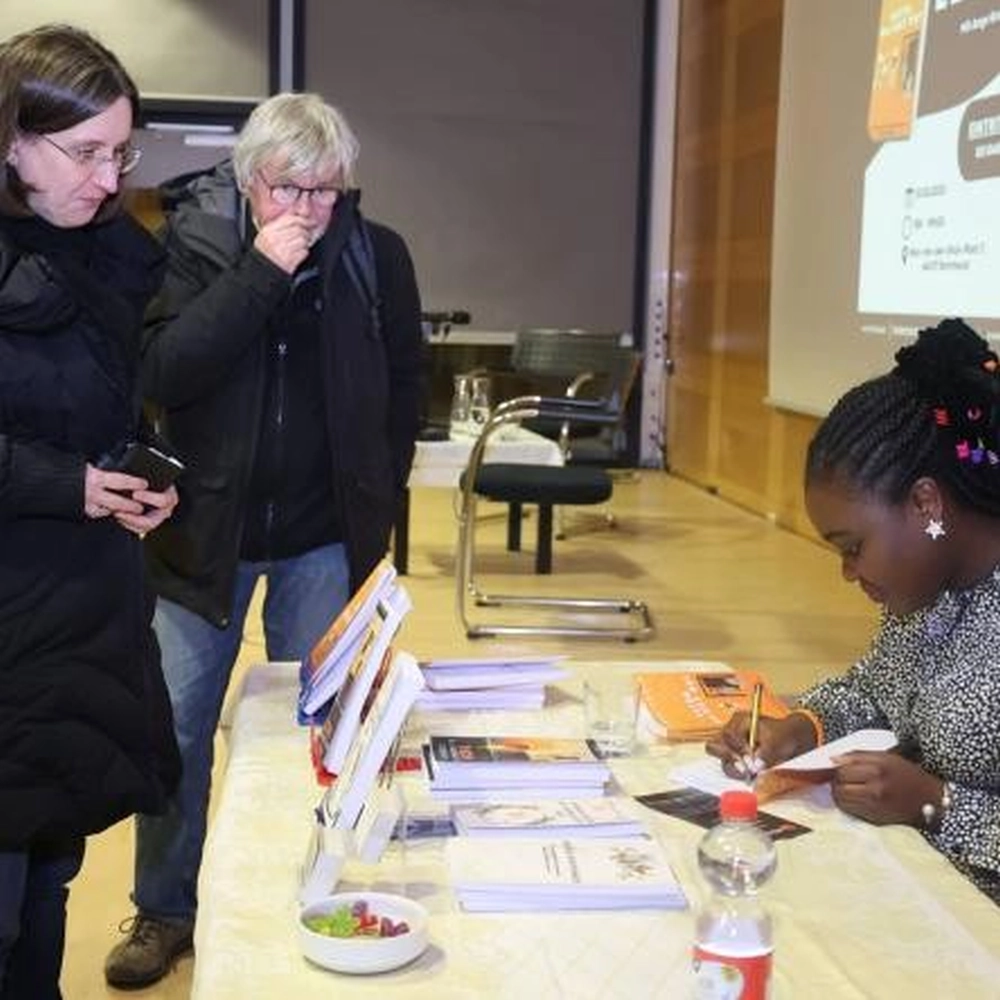 Frau schreibt etwas in ein Notizbuch - Afrikultur e.V.